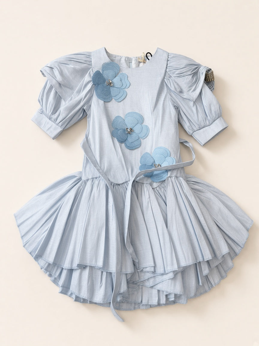 Icy blue floral appliqué party frock flat lay on cream studio
