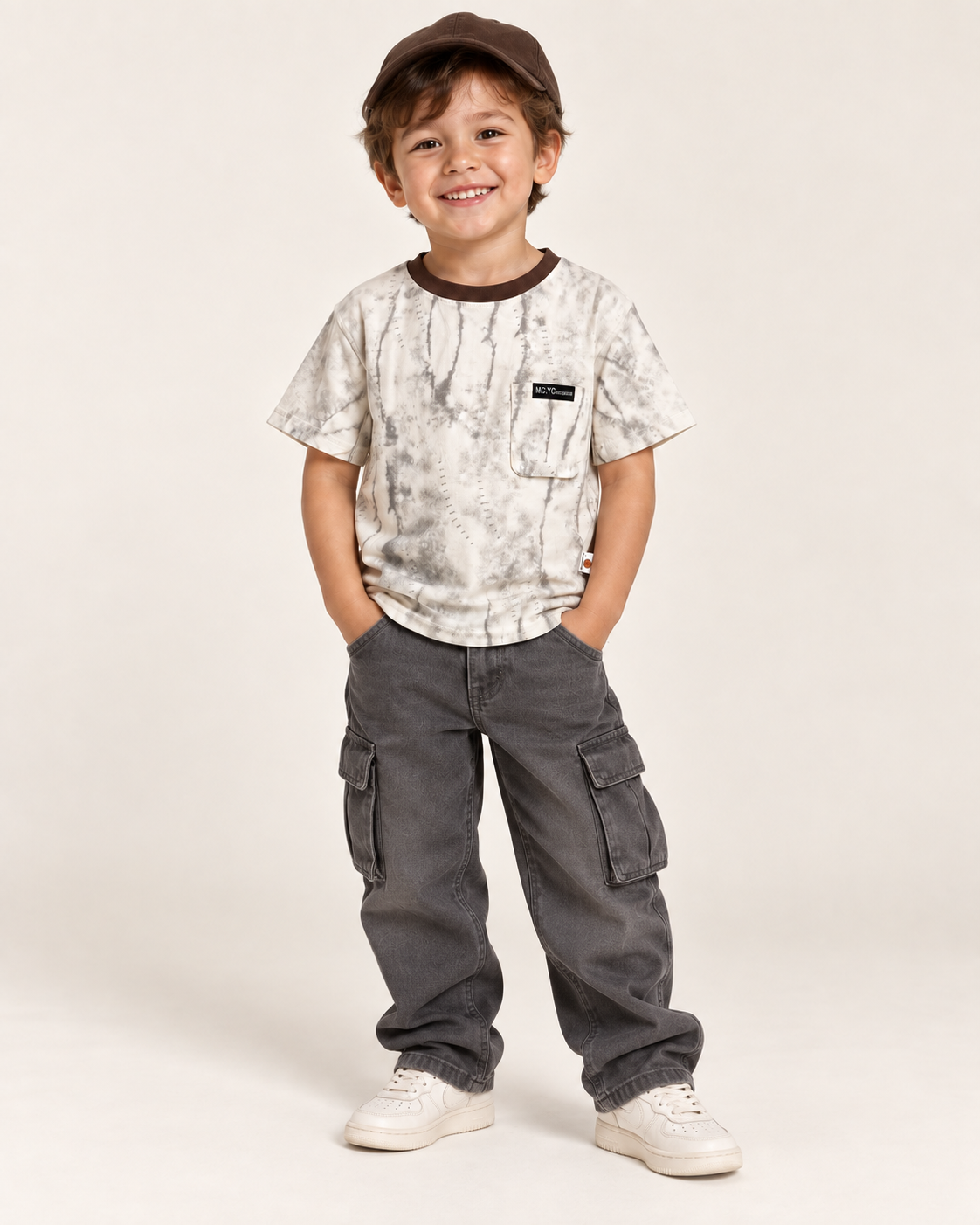 Boy wearing the cream and grey marbled pocket T-shirt with baggy charcoal cargo pants